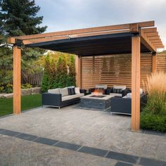 an outdoor living area with couches and a wooden pergoline structure in the background