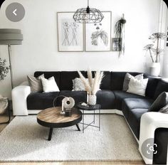 a black and white living room with lots of pillows on the couch, coffee table