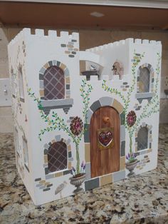 a paper model of a castle with flowers on the front door and windows in it