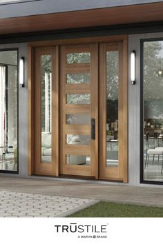 the front door of a house with glass and wood