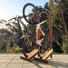 two bikes are mounted to the side of a wooden stand