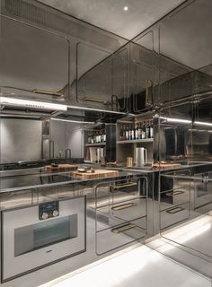 an industrial kitchen with stainless steel appliances and counter tops is pictured in this image, it appears to be reflecting light from the ceiling