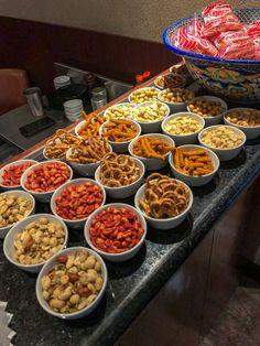 a table filled with lots of different types of snacks on top of plates and bowls