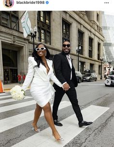 a man and woman are walking across the street