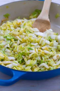 a blue skillet filled with cabbage and onions