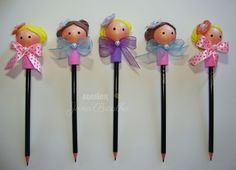 four pencils with little dolls on them