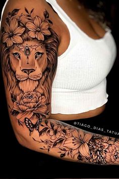 a woman's arm with a lion and flowers tattoo on her left arm, which is covered in black ink