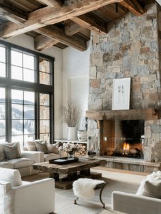 a living room filled with lots of furniture and a fire place in front of a large window