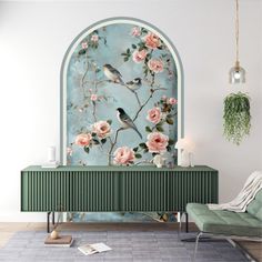 a living room with flowers and birds painted on the wall next to a green cabinet