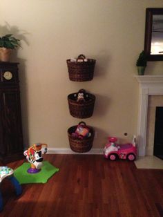 a living room filled with furniture and toys on top of a hard wood floor next to a fire place