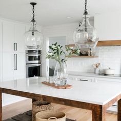 a kitchen with white counter tops and wooden floors