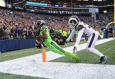 two football players in action on the field during a game with an audience behind them