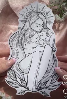 a woman holding a baby in her arms with the image of jesus and mary on it