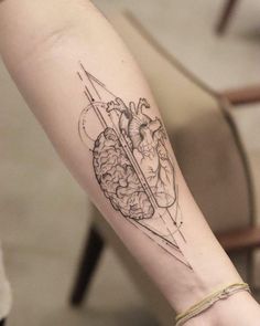 a woman's arm with a tattoo on it and an arrow in the shape of a brain