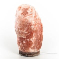 a large pink rock sitting on top of a white table next to a light bulb