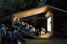 people are sitting on the steps in front of an open air structure at night time