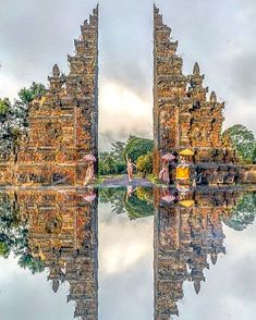 the reflection of two towers in water is very colorful and artistic, with people walking around it