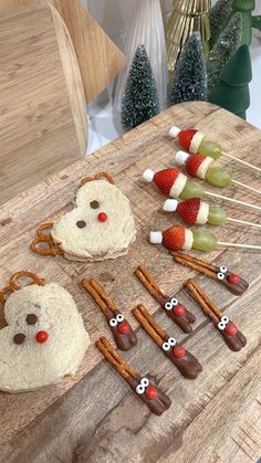 a wooden cutting board topped with pretzels and marshmallows covered in candy