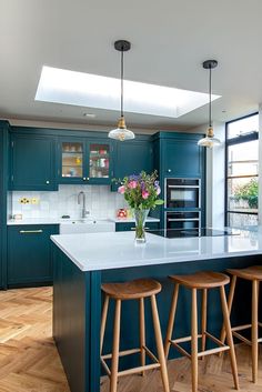 a kitchen with blue cabinets and wooden stools