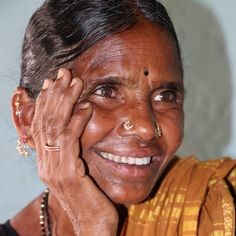 an old woman smiling and holding her hands to her face