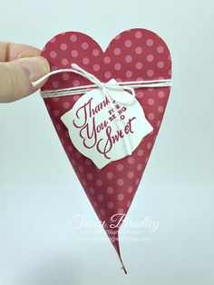 a hand holding up a heart shaped card