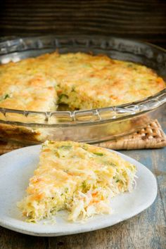 a slice of quiche on a plate next to a casserole dish