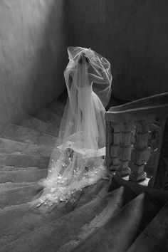 a veiled bride is walking down the stairs