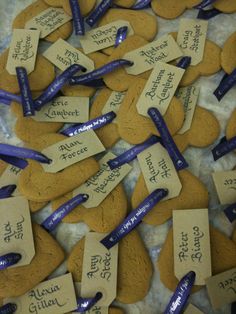 several pieces of heart shaped cookies with name tags on them and blue ribbons attached to them