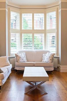 a living room with two couches and a coffee table in front of the window