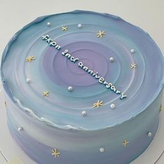 a blue cake with white frosting and stars on it that says happy anniversary written in the middle