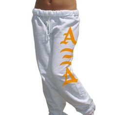 a woman wearing white sweat pants with orange letters on the side