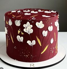 a red cake with white flowers on it