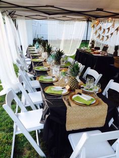 a table set up with pineapple plates and place settings for an outdoor wedding reception