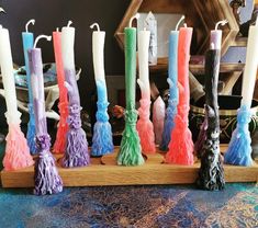 a row of colorful candles sitting on top of a wooden stand