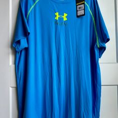 a blue under armour shirt hanging on a white door with a tag attached to it