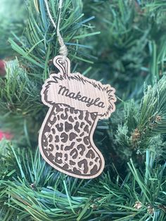 a wooden ornament hanging from a christmas tree with the name makaua on it