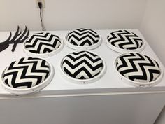 four black and white chevron plates sitting on top of a refrigerator freezer door