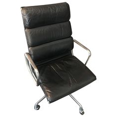 a black leather office chair with chrome frame and footrests on an isolated white background