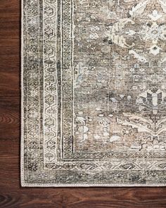 an antique rug on a wooden floor with dark brown and white tones, including the border