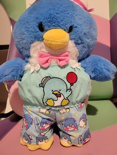 a blue stuffed animal with a pink bow tie on it's head and wearing pajamas