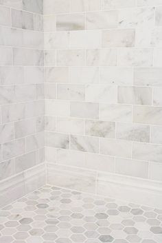 a white tiled shower with hexagonal tiles