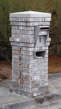 a brick mailbox sitting on the side of a road