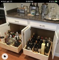 an open cabinet with wine bottles in it