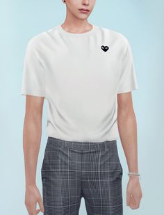 a young man wearing a white t - shirt with a heart on the chest and black checkered pants