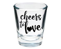 a shot glass with the words cheers to love written in black ink on white background