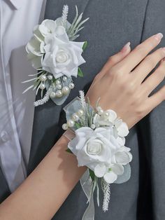 the bride and groom are dressed in gray suits with white flowers on their lapels