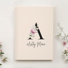 a book with the letter a on it next to flowers