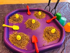 a purple tray filled with dirt and plastic scoops