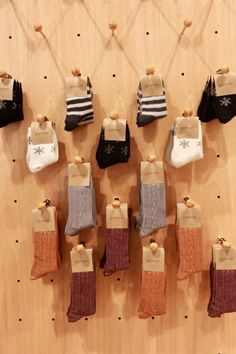 there are many pairs of socks hanging on the pegs in front of each other