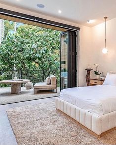 a bedroom with a large bed and sliding glass doors leading to an outside patio area